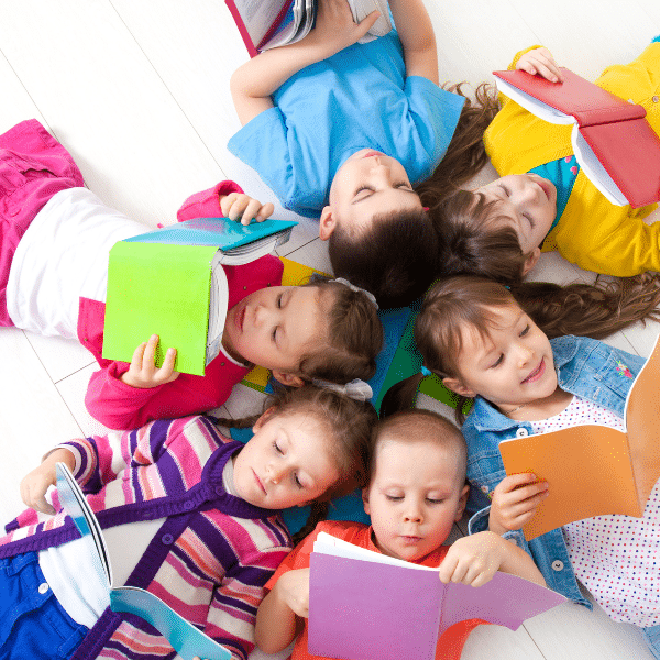 image showing a group of children laying on the floor reading books